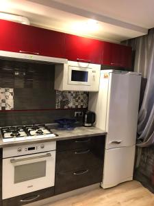 a kitchen with a white refrigerator and a microwave at VIP Apartment on Khrutskogo in Polatsk