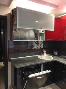 a kitchen with a sink and a red cabinet at VIP Apartment on Khrutskogo in Polatsk
