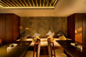 a dining room with a table and chairs and a couch at SSAW Boutique Hotel Hangzhou Wildwind in Hangzhou