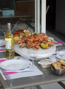 a table with a pizza and a bottle of wine at Les rives du lac in Le Grau-du-Roi