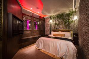 Schlafzimmer mit einem Bett mit roter Decke in der Unterkunft Forbidden City Motel in Taichung
