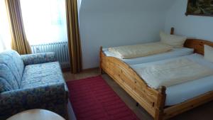 niewielka sypialnia z łóżkiem i krzesłem w obiekcie Pension Mühlencafé w mieście Breitnau