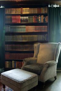 a chair in front of a library with books at Seljord Hotel - Unike Hoteller in Seljord