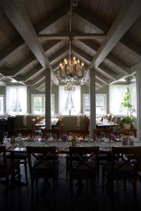 a dining room with tables and chairs and a chandelier at Seljord Hotel - Unike Hoteller in Seljord