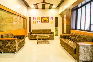 - une salle d'attente avec des canapés et une table basse dans l'établissement FabExpress Karishma Rasta Peth, à Pune