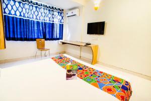 FabExpress Karishma Rasta Peth في بيون: غرفة مع أرضية ملونة في غرفة