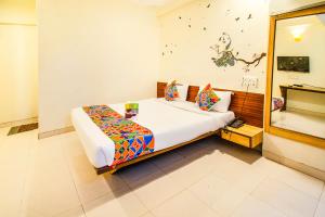 a bedroom with a bed in a room at FabExpress Karishma Rasta Peth in Pune