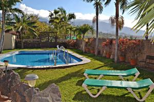 a swimming pool with a bench next to a yard at Casa Victor in La Orotava