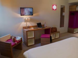 een kamer met een bed en een bureau met een laptop bij ibis Styles Castres in Castres