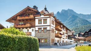 a building in a town with mountains in the background at Hotel Sendlhof in Waidring