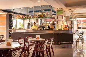un restaurante con mesas y sillas y un camarero en htop Summer Sun #htopEnjoy, en Santa Susanna