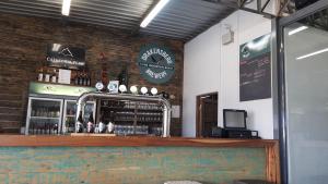 a bar with a counter with bottles of alcohol at Pilot's Cabin, El Mirador Airfield in Champagne Valley