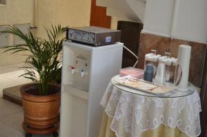 a microwave on top of a refrigerator next to a table at Hotel Plaza Cúcuta Center in Cúcuta