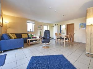 a living room with a blue couch and a table at Ferienhaus Lobbe - Wohnung 04 mit Terrasse strandnah in Lobbe