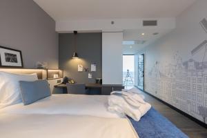 una camera con letto bianco e scrivania di Postillion Hotel Amsterdam ad Amsterdam