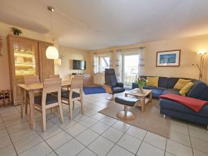 sala de estar con sofá azul y mesa en Ferienhaus Lobbe - Wohnung 04 mit Terrasse strandnah en Lobbe