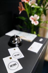 une table noire avec des cartes et un vase avec des fleurs dans l'établissement Hotel Antonio, à Oujhorod