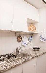 a kitchen with white cabinets and a sink at La Vignaredda - Residenza di Charme in Aggius