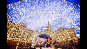 a group of people walking under a tunnel with lights at Anemona's House In The Center Of Sibiu in Sibiu
