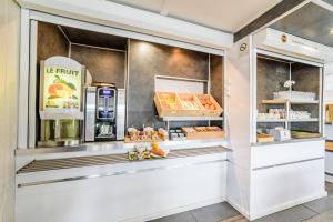 a bakery with a counter with food in it at B&B HOTEL Belfort Bessoncourt in Belfort