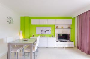 a dining room with a table and a green wall at Llepol in Port d'Alcudia
