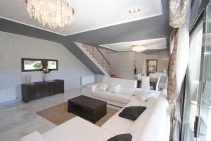 a living room with a white couch and a chandelier at ARENDA Villa Perla in Hospitalet de l'Infant