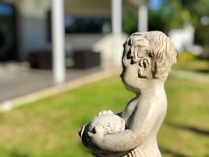 a statue of a child holding a ball at ARENDA Villa Perla in Hospitalet de l'Infant