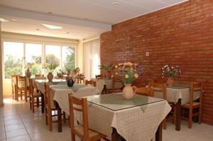 a restaurant with tables and chairs and a brick wall at Poseidon Hotel in Heraklio