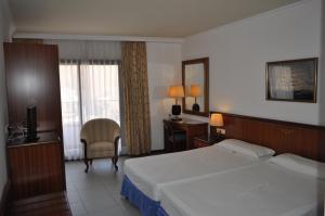 a bedroom with a bed and a desk and a television at Hostal Vila del Mar in Lloret de Mar