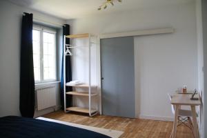 a bedroom with a bed and a closet and a window at Maison Boulvern in Plomodiern