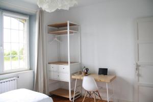 a bedroom with a desk and a bed and a window at Maison Boulvern in Plomodiern