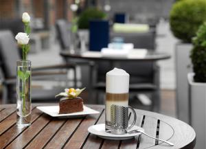 - une table avec une bougie et une assiette avec un gâteau dans l'établissement Crowne Plaza Budapest, an IHG Hotel, à Budapest
