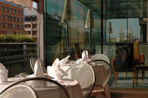 ブダペストにあるCrowne Plaza Budapest, an IHG Hotelの白いナプキンを掛けたテーブルと椅子