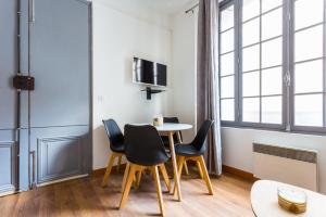 a dining room with a table and chairs and a window at CMG Palais des Congrès/ Ternes in Paris