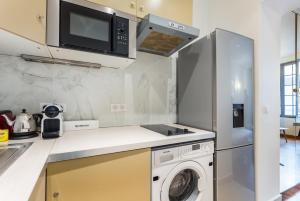 a kitchen with a washing machine and a microwave at CMG Palais des Congrès/ Ternes in Paris