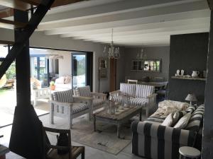 a living room with couches and chairs and a table at Pringle @ 865 Jally in Pringle Bay