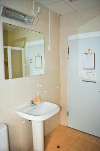 Un baño con un lavabo blanco y un espejo. en Pension Castil, en Granada