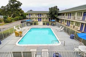 a swimming pool at a resort with chairs and umbrellas at Motel 6-San Marcos, TX in San Marcos