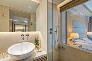 a bathroom with a large white sink and a shower at Rodos Park in Rhodes Town
