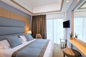 a hotel room with a bed and a television at Rodos Park in Rhodes Town
