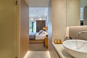 a bathroom with a sink and a bedroom at Rodos Park in Rhodes Town