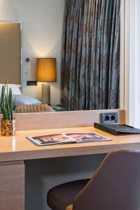 a desk in a hotel room with a bed and a desk with a laptop at Rodos Park in Rhodes Town