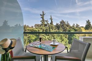 a table and chairs on a balcony with a view at Rodos Park in Rhodes Town