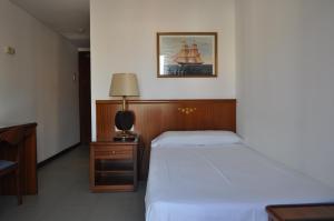 a bedroom with a bed and a desk with a lamp at Hostal Vila del Mar in Lloret de Mar