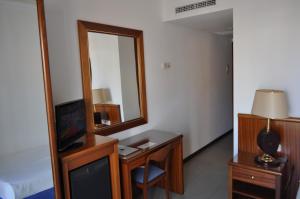a room with a mirror and a desk with a television at Hostal Vila del Mar in Lloret de Mar
