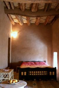 a bedroom with a bed and a table with a bowl of fruit at kasbah timidarte in Zaouïta Bou Lhâssane
