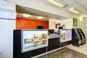 a waiting area of a store with a sign that reads wet leave the light on at Motel 6-Portland, ME in Portland