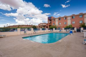 une piscine dans un hôtel avec des chaises et un bâtiment dans l'établissement Motel 6-Page, AZ, à Page