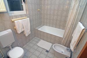 y baño con aseo, bañera y lavamanos. en Nirvana Accommodation, en Bucarest