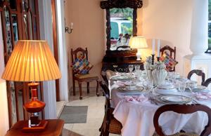 uma sala de jantar com uma mesa com placas e um candeeiro em The Castle em Katunayaka